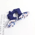 Détail d'un chouchou bleu foncé à motif floral avec nœud oreilles de lapin sur blanc - Style Floral Blanc Bleu Patchwork Bleu Foncé
