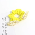 Gros plan sur chouchou jaune avec nœud floral sur une carte de présentation blanche - Style Floral Jaune Patchwork Jaune Vif