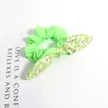 Gros plan d'un chouchou vert fluo avec un détail de nœud floral sur fond blanc pur - Style Floral Vert Patchwork Vert Néon