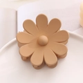 Gros plan d'une pince à cheveux fleur de marguerite mate beige crème sur fond neutre - Marron