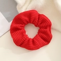 Close-up of red chunky knit scrunchie texture with detailed weave on plush background - Red