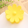 Détail d'une pince à cheveux mate en forme de marguerite jaune sur un plateau décoratif - Jaune