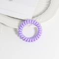 Detail of light purple spiral telephone wire hair tie on a white decorative plate - Color 1
