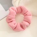 Close-up of pink knitted scrunchie showing the soft waffle texture and elastic fabric detail - Pink