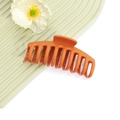 Dettaglio macro di un grande fermaglio per capelli arancione opaco con denti a incastro - No.1 Rosso Arancio