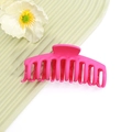 Primo piano di un grande fermaglio per capelli rosso rosa opaco con design multi-dente su verde - No.2 Rosa Rosso