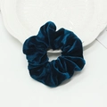Chouchou en velours bleu paon foncé avec texture plissée douce sur une assiette blanche - Cyan