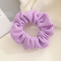 Detailed macro view of purple knitted scrunchie showing soft yarn texture and elastic design - Purple