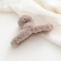 Dettaglio del fermaglio per capelli in peluche rosa cipria con morbida texture in finta pelliccia - Caffè Chiaro