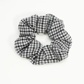 Close-up detail of the classic black and white houndstooth pattern on the fabric scrunchie - Black