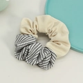Dettaglio di un elastico per capelli con maglia a coste beige e tessuto a quadretti neri - Beige