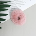 Detailopname van een roze scrunchie van imitatiebont op een decoratieve achtergrond - Roze