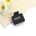 Dettaglio di una grande pinza per capelli quadrata nero opaco su un vassoio decorativo - Pinza quadrata