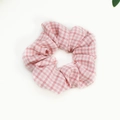 Close-up of pink and white gingham fabric scrunchie with soft ruffled texture - Pink