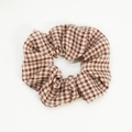 Macro shot of red and white houndstooth pattern scrunchie with soft fabric texture - Red