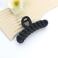 Close-up of large matte black shark hair claw clip with curb chain design on a wave board - Cuban Chain Style