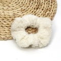 Chouchou blanc en laine d'agneau duveteuse sur tapis en paille pour l'hiver - Beige