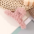 Primer plano de pinza para el cabello de lana de cordero rosa con textura de felpa suave - Rosa