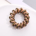 Detailed macro view of spiral telephone wire hair ties in coffee, green, and pink mix - Beige Green Coffee