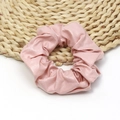Dettaglio dello scrunchie in pelle PU rosa che mostra la trama raffinata e la lucentezza - Rosa