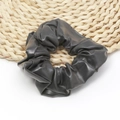 Trama dettagliata dell'elastico scrunchie in ecopelle grigia su sottobicchiere in paglia - Nero
