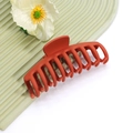 Vue détaillée d'une grande pince à cheveux orange mat sur plateau texturé vert ondulé - No.26 Orange Mat