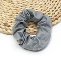 Detailed close-up showing the soft grey PU leather texture of the elastic hair scrunchie - Gray