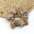 Elegant champagne gold PU leather oversized scrunchie hair tie on woven coaster - Khaki