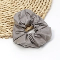 Detailed view of the soft grey faux leather scrunchie with elegant pleated texture - Mud Grey