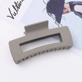 Détail d'une grande pince à cheveux rectangulaire gris chaud mat sur un magazine de mode - Style Rectangulaire Creux / Gris