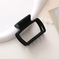 Detail of matte black rectangular hollow hair claw clip on a minimalist white ceramic tray - 1# Black