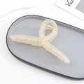 Detail of a large cream yellow translucent acrylic hair claw clip with golden metal spring - Beige