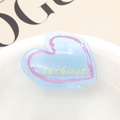 Pinza de pelo de acetato azul claro en forma de corazón con texto luckiest sobre revista - Corazón Azul Claro (1)