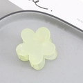 Close-up of a light green matte flower hair claw clip on a gray textured plate - Cyan