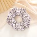 Detailed view of floral scrunchie in cream white and purple with soft fabric folds - White