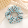 Close-up of floral scrunchie with red tulip patterns on light blue fabric - Light Blue