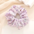 Close-up of pink floral scrunchie with soft purple flower prints on premium fabric - Purple
