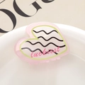 Vista macro de la pinza de pelo corazón rosa con texto luckiest y detalles de ondas en porcelana - Onda Rosa Negra (4)