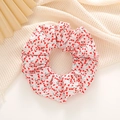 Close-up of a white scrunchie with red tulip floral pattern and soft pleated fabric texture - Red