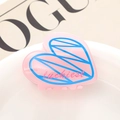 Gros plan sur la pince à cheveux cœur rose avec gravure Luckiest sur une assiette blanche - Ligne Rose Bleue (6)