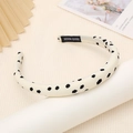 Dettaglio ravvicinato di un cerchietto largo a pois neri con etichetta fatta a mano - Stile Beige con Pois Neri / Beige