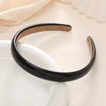 Elegant thick black faux leather headband with non-slip lining on a ceramic tray - Black
