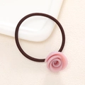 Close-up of pink resin rose charm on high-elasticity brown hair tie accessory - Pink