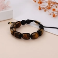 Close-up of woven yoga bracelet featuring tiger eye stone and black lava rock beads - Tiger Eye