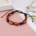 Detail view of woven yoga bracelet with oval red jasper and black lava stone beads - Oval Red Sandstone