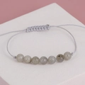 Macro shot of grey natural stones on an adjustable light grey woven beaded bracelet - Moonstone Gray Line (BNS-0209)