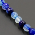Macro shot of faceted blue agate beads with natural stripes for DIY jewelry making - 8mm / Faceted Striped Blue