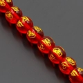 Macro shot of red translucent crystal beads with gold Mantra engraving for DIY jewelry - Red