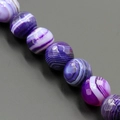 Dettaglio macro di perle di agata a strisce viola naturali con texture lucida - 4mm / Agata a Strisce Viola (MS-0012-2)