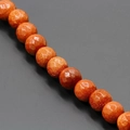 Nahaufnahme facettierter orangefarbener Goldstein-Perlen mit funkelnden Metalleffekten - Facettierter Goldsand / 8mm